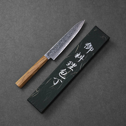 SG2 damascus petty knife with olive wood handle, presented in its black box with white Japanese characters; photographed to showcase the blade’s intricate damascus pattern, compact form, and warm wood grain of the handle against the elegant packaging backdrop.