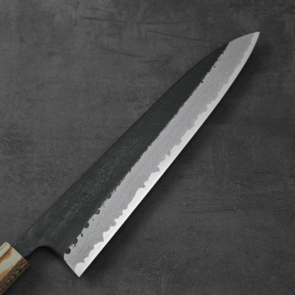 A gyuto with damascus blade and wood handle, featuring a kurouchi finish.