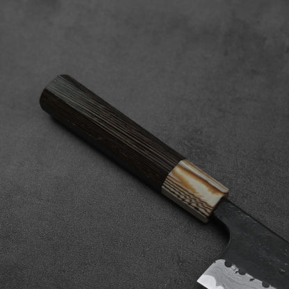 Close-up of a gyuto showing kurouchi damascus pattern and AS steel, blade edge and spine clearly visible.