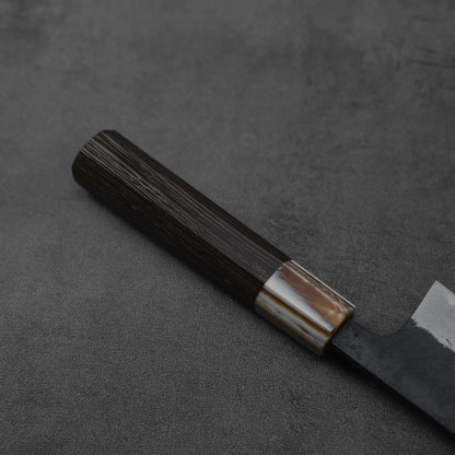 Close-up of a gyuto with kurouchi and damascus finish, emphasizing blade patterns and textures.