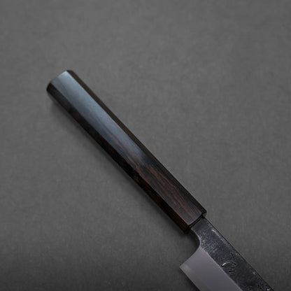 A close-up of a kitchen knife with a dark wooden handle and a partially visible metal blade, carefully arranged on a dark grey surface.