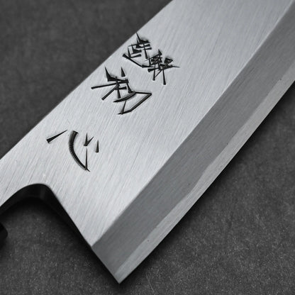 Close-up of the Hatsukokoro Shirasagi shirogami#2 deba 165mm Japanese fish knife, featuring a Shirogami#2 carbon steel blade engraved with Japanese characters, resting on a dark gray surface.