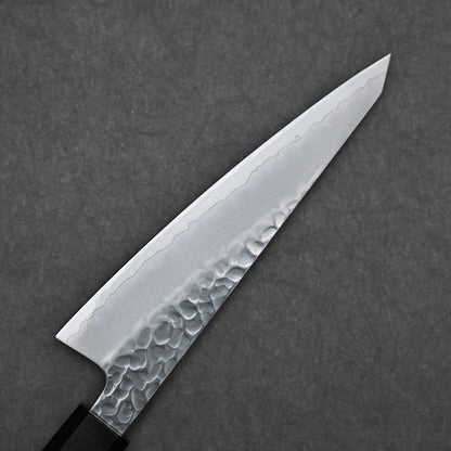 A close-up of the Hatsukokoro tsuchime ginsan honesuki 150mm chef knife, featuring a hammered tsuchime finish and wavy patterned blade, set against a dark gray textured background.