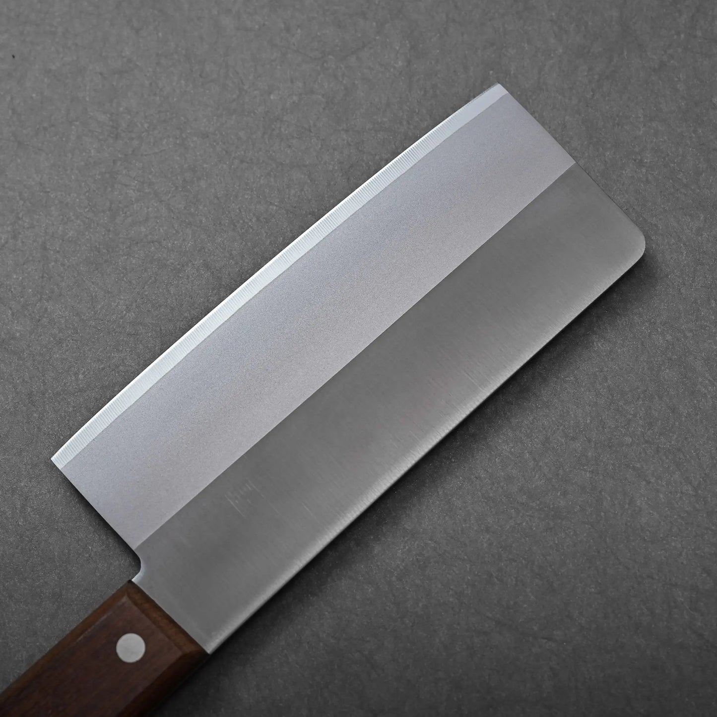 A close-up shows the rectangular blade and part of the wooden handle of a Japanese knife, a chuka bocho cleaver.