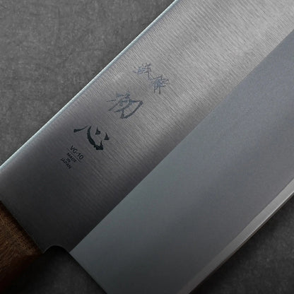 Close-up shows kanji characters on the blade and a wooden handle of this Japanese knife, a chuka bocho cleaver.