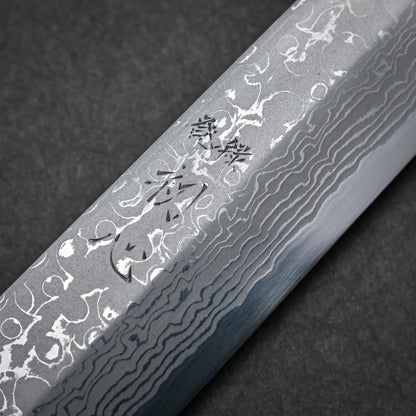 Close-up of a Damascus sashimi knife blade showcasing intricate wavy patterns and Japanese characters engraved on the surface, set against a dark background.