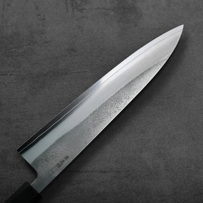 A gyuto chef's knife with a nashiji finish displayed, highlighting its length and detailed blade texture.
