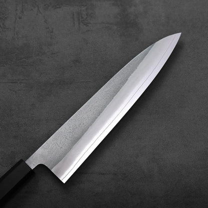 A close-up of a gyuto highlights the textured nashiji finish and 210mm blade from an overhead angle.