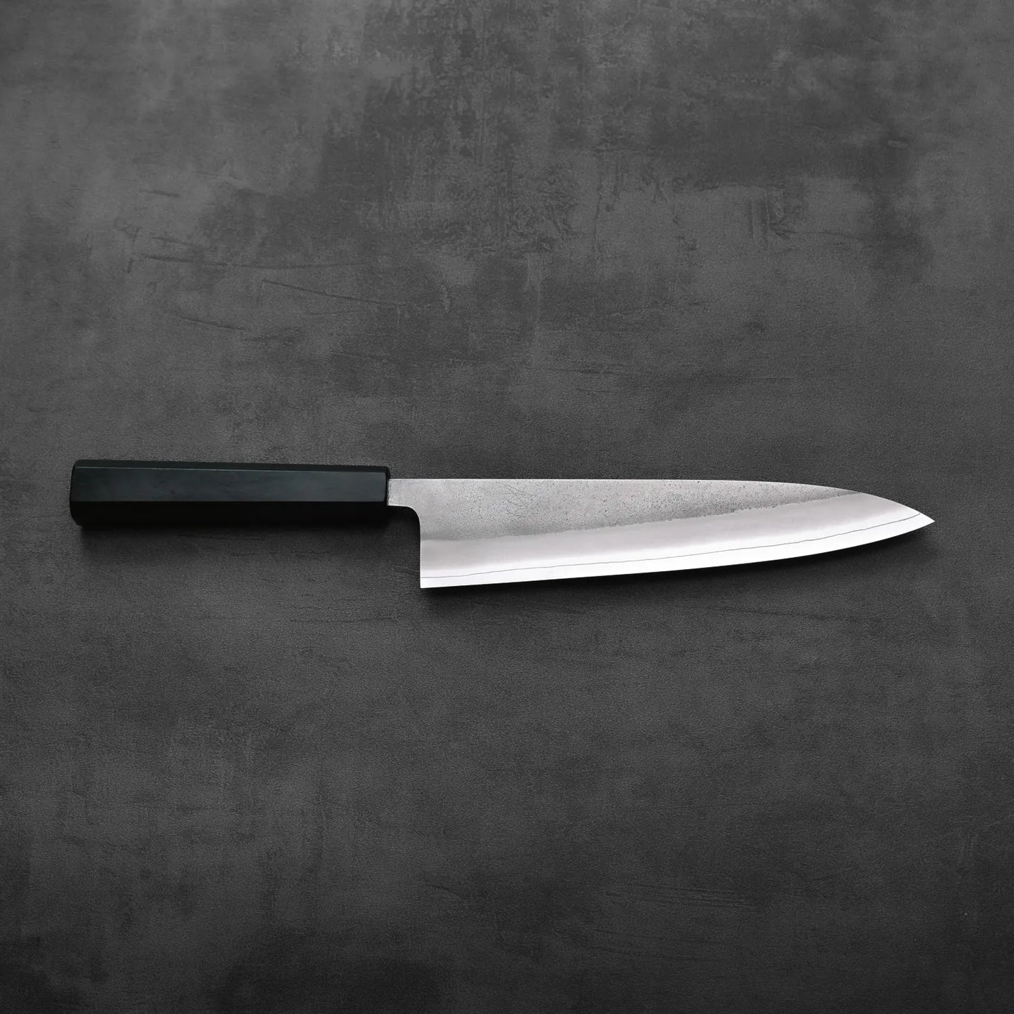 A gyuto with a black handle, 210mm in length, is shown. The stainless blade features a nashiji finish.