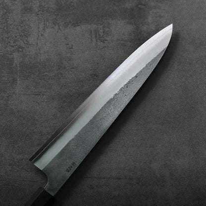 A close-up of a gyuto knife, highlighting its detailed nashiji finish and 240mm blade length.