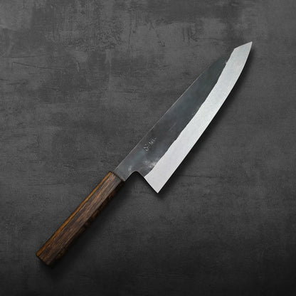 Gyuto with a dark wood handle, emphasizing the blade's height and design details.