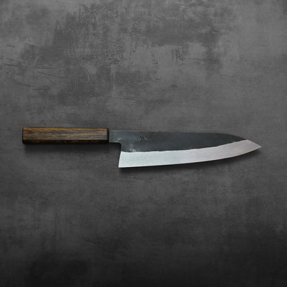 A gyuto with a wooden handle, featuring a tall blade, is displayed without background elements visible.
