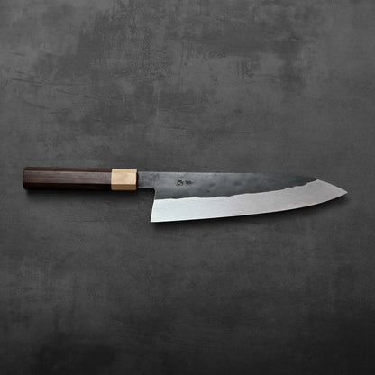 Gyuto with a dark wood handle, featuring a tall blade and balanced proportions.