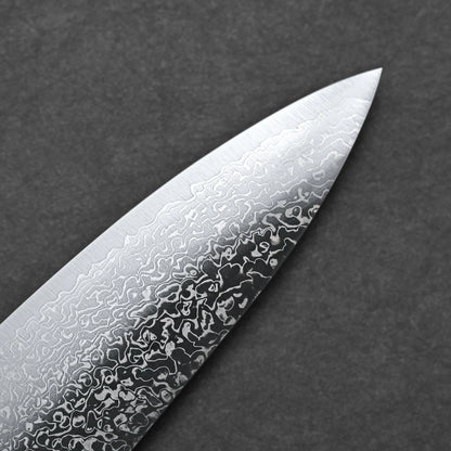 Close-up of the tip of the Kei Kobayashi SG2 damascus gyuto 240mm kitchen knife blade, showing its wavy, patterned texture against a plain dark gray background.