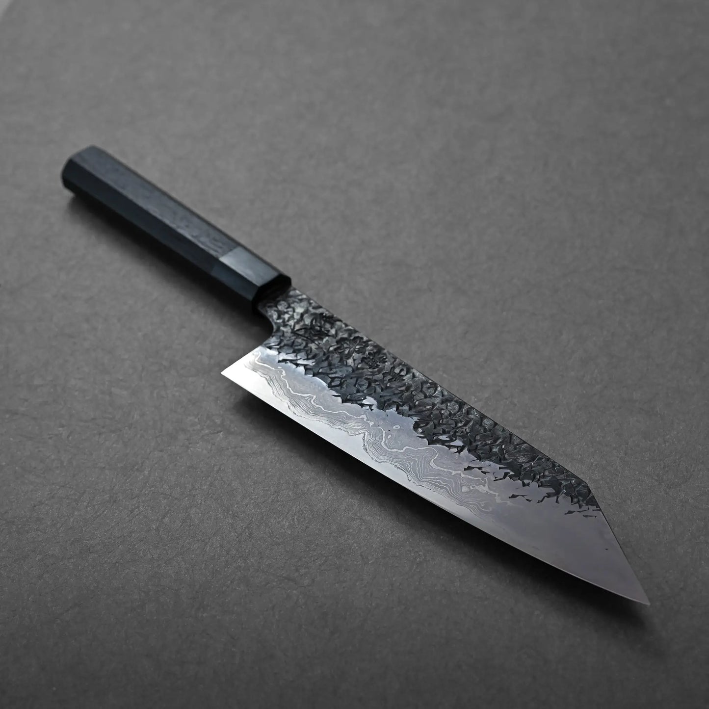 A blade with a straight edge and angled tip, Japanese knife kiritsuke gyuto, textured finish, dark octagonal handle.