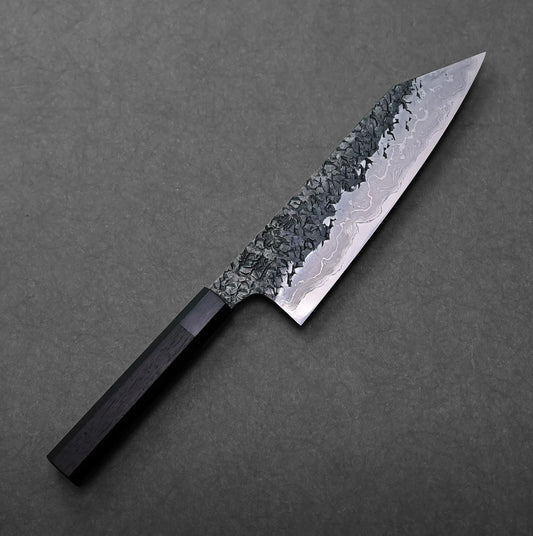Kisuke Manaka ENN  kiritsuke gyuto 215mm with kiritsuke gyuto shape, straight edge, and dark handle visible in the shot.