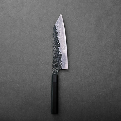 A Japanese knife with a kiritsuke gyuto shape, featuring a textured, patterned blade and black handle.