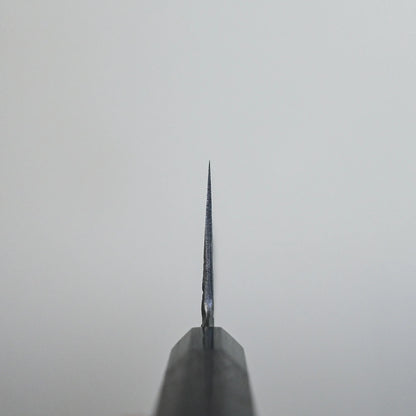 Choil shot of a Japanese knife, handforged steel finish visible along the sharpened blade.