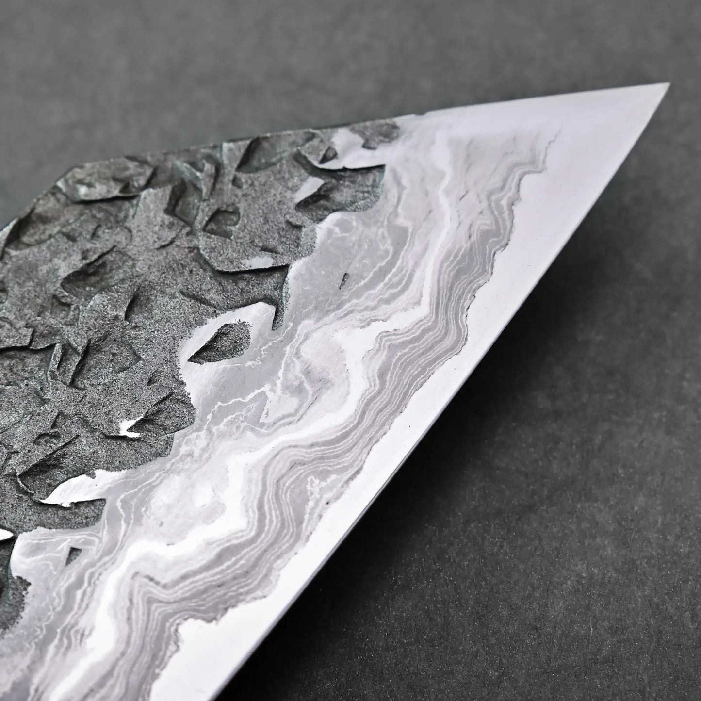 Close-up shows wavy Aogami #1 damascus patterns on a Japanese knife blade; only the blade details are visible.