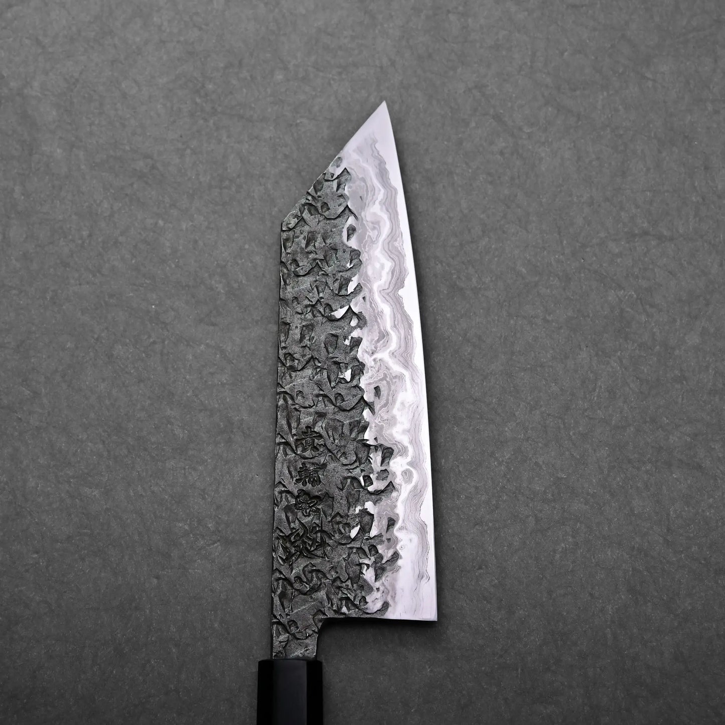 A close-up shows a Kisuke Manaka Japanese knife with a visible handforged blade, highlighting its angled bunka tip.