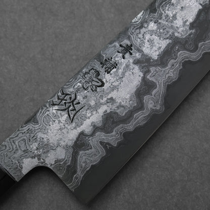Close-up of a Damascus steel knife blade with engraved characters on a dark background