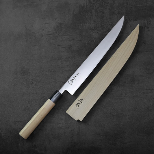 A sujihiki with saya shown in a resting position, highlighting its slim blade and wooden sheath.
