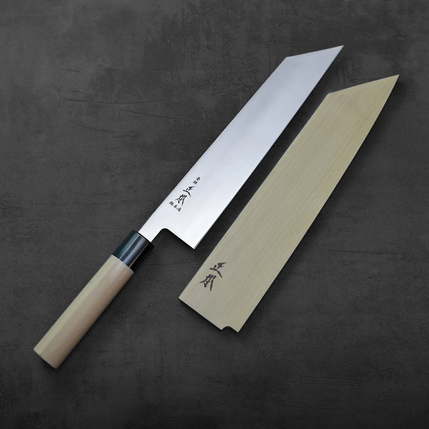 Kiritsuke gyuto with saya, 240mm blade. No mention of background or setting included in this description.
