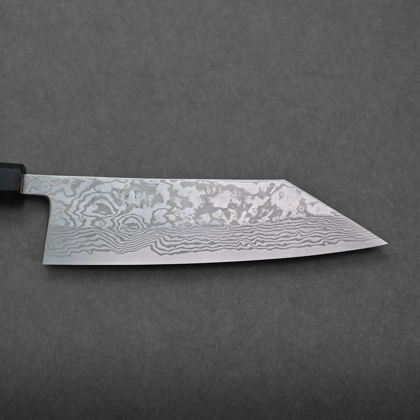 A close-up view of a Miyazaki ATS34 Japanese kitchen knife with a Damascus steel blade, showing detailed wavy and mottled patterns on a gray background.