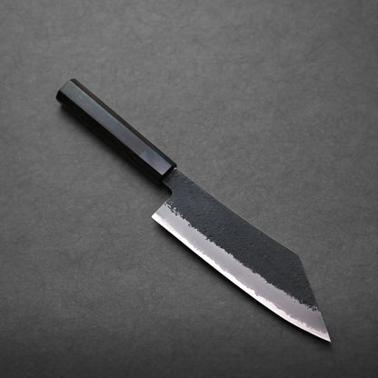 A Japanese-style hakata knife with a dark handle and a wide, angular blade featuring a textured, matte upper section and a polished, sharp edge, placed on a dark gray surface.