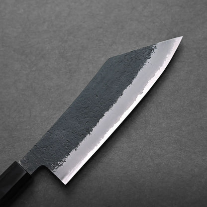 Close-up of a hakata knife with a black textured upper blade and a sharp, polished cutting edge, set against a dark grey background.