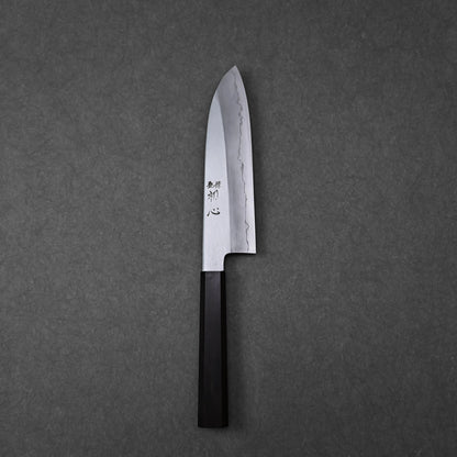 Santoku knife shown in full profile with vertically engraved kanji characters near the handle; photographed in a vertical orientation to highlight the blade and handle together.