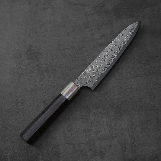 Petty knife with a dark handle, blade featuring visible damascus pattern.