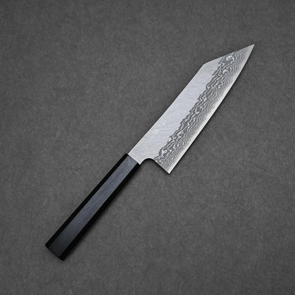 The Nigara tsuchime damascus VG10 bunka 180mm, featuring a patterned blade of Takefu VG10 stainless steel and a black octagonal handle, rests on a dark grey textured surface.