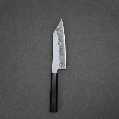 The Nigara tsuchime damascus VG10 bunka 180mm knife with a black handle rests on a flat, dark gray surface.