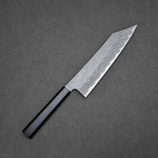A Nigara tsuchime damascus VG10 kiritsuke gyuto 210mm kitchen knife with a black handle and patterned steel blade, photographed on a dark gray textured surface. The blade features distinctive wavy Damascus patterns.