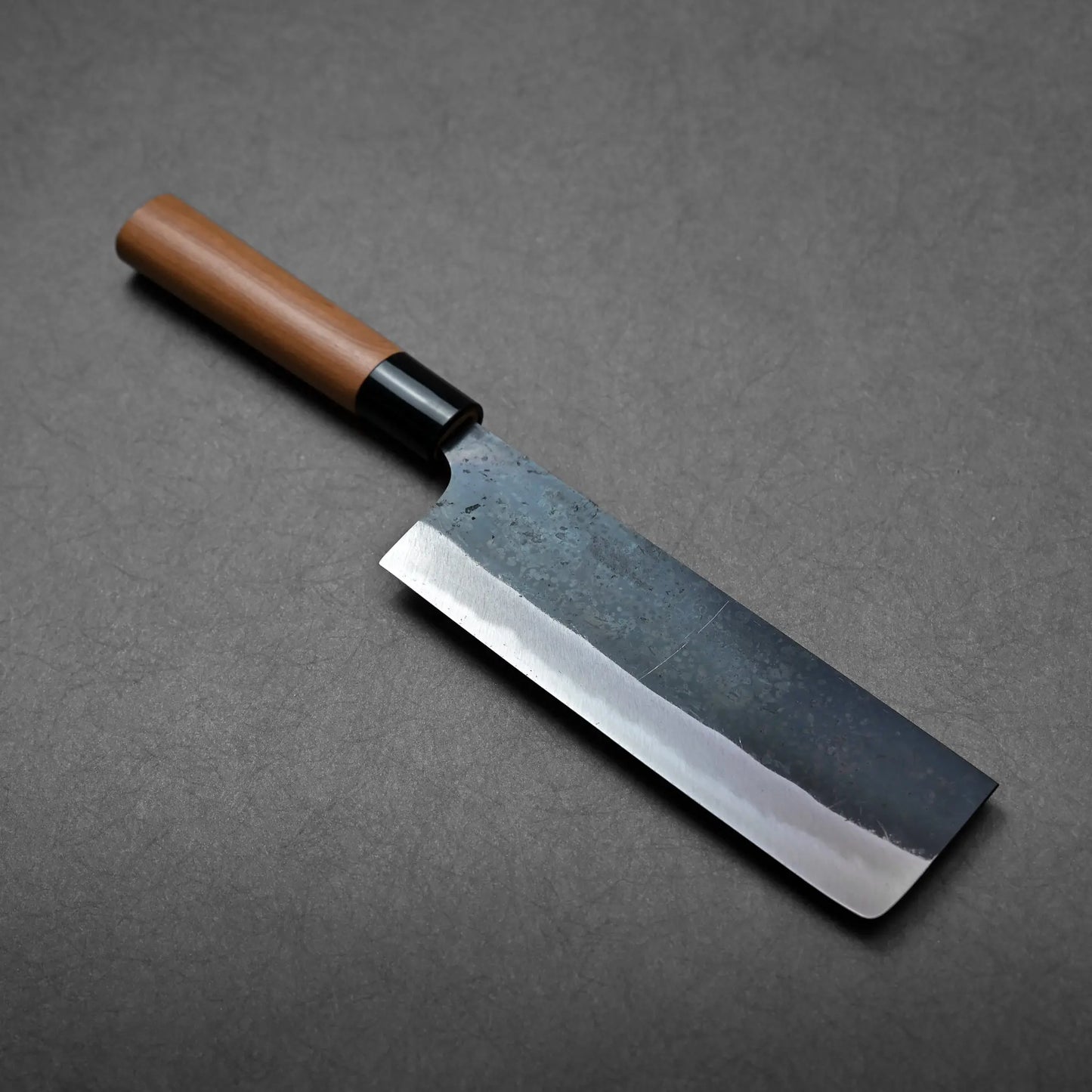 Rectangular blade with straight edge and a wooden handle, this Japanese knife appears to be a nakiri.