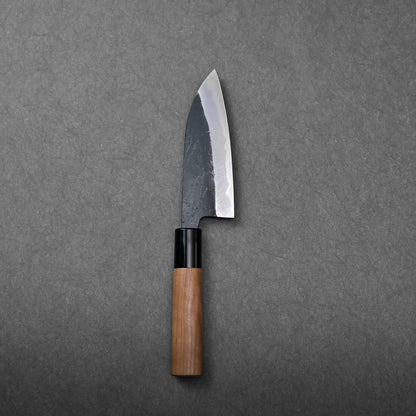 Wooden-handled Japanese knife with a visible angled dark blade; the shape suggests it is a petty knife.