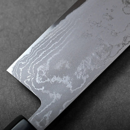 Close-up of nakiri blade with straight edge, squared tip, Japanese knife featuring visible Damascus steel pattern.