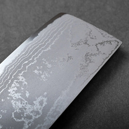 The flat-edged, rectangular blade of this Japanese knife displays a visible wavy Damascus steel pattern up close.