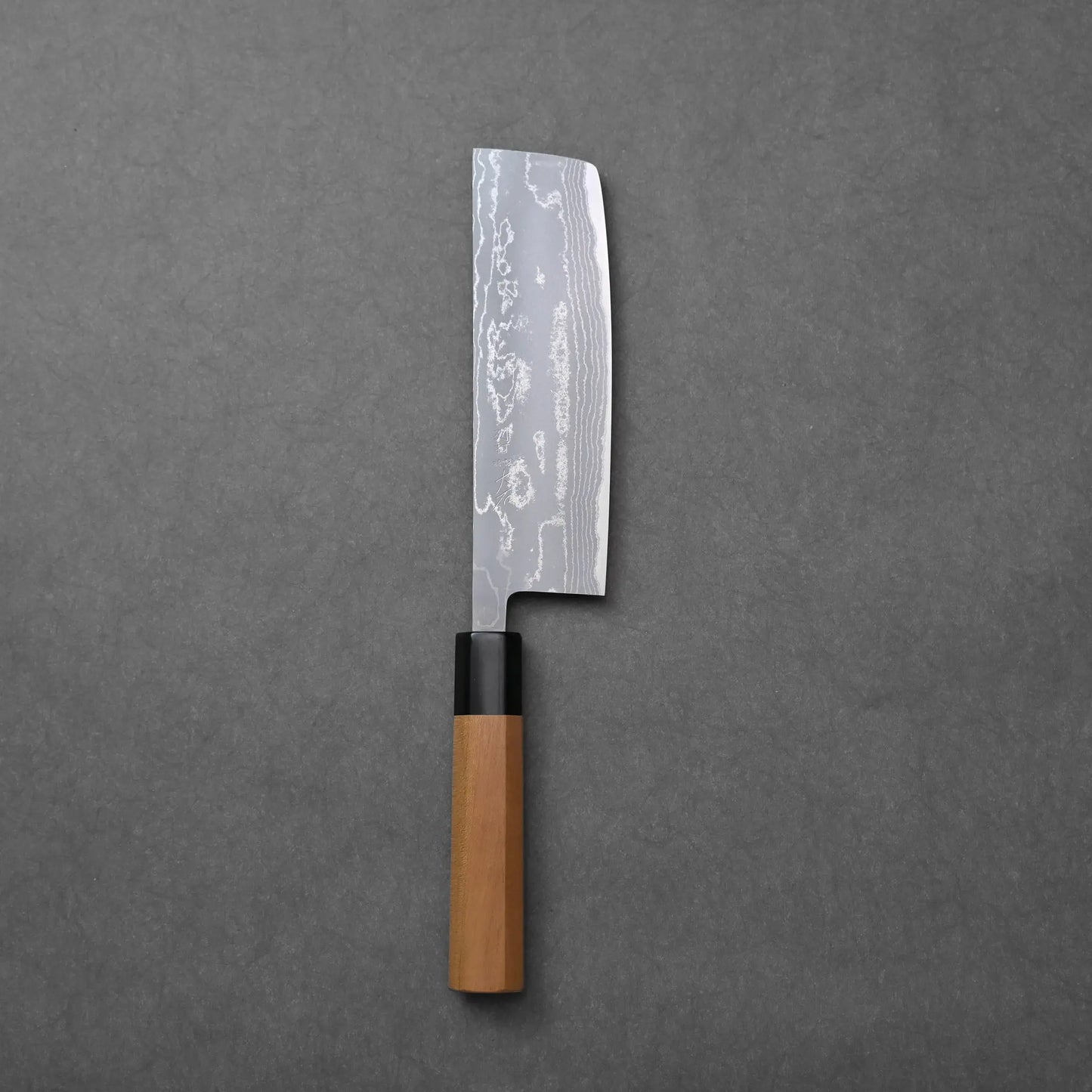 Rectangular-bladed Japanese knife with a wooden handle and patterned steel, identifiable as a nakiri.