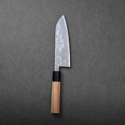 A santoku blade with a damascus pattern and wooden handle shows the Japanese knife’s distinctive sheep’s foot shape.
