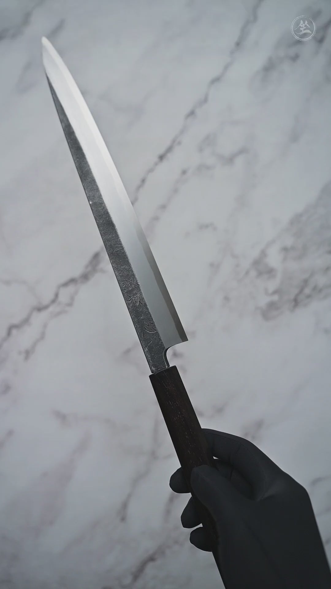 Short video showcasing an aogami#2 kurouchi yanagiba knife from Hatsukokoro rotating to display the blade, handle, and overall craftsmanship from multiple angles.