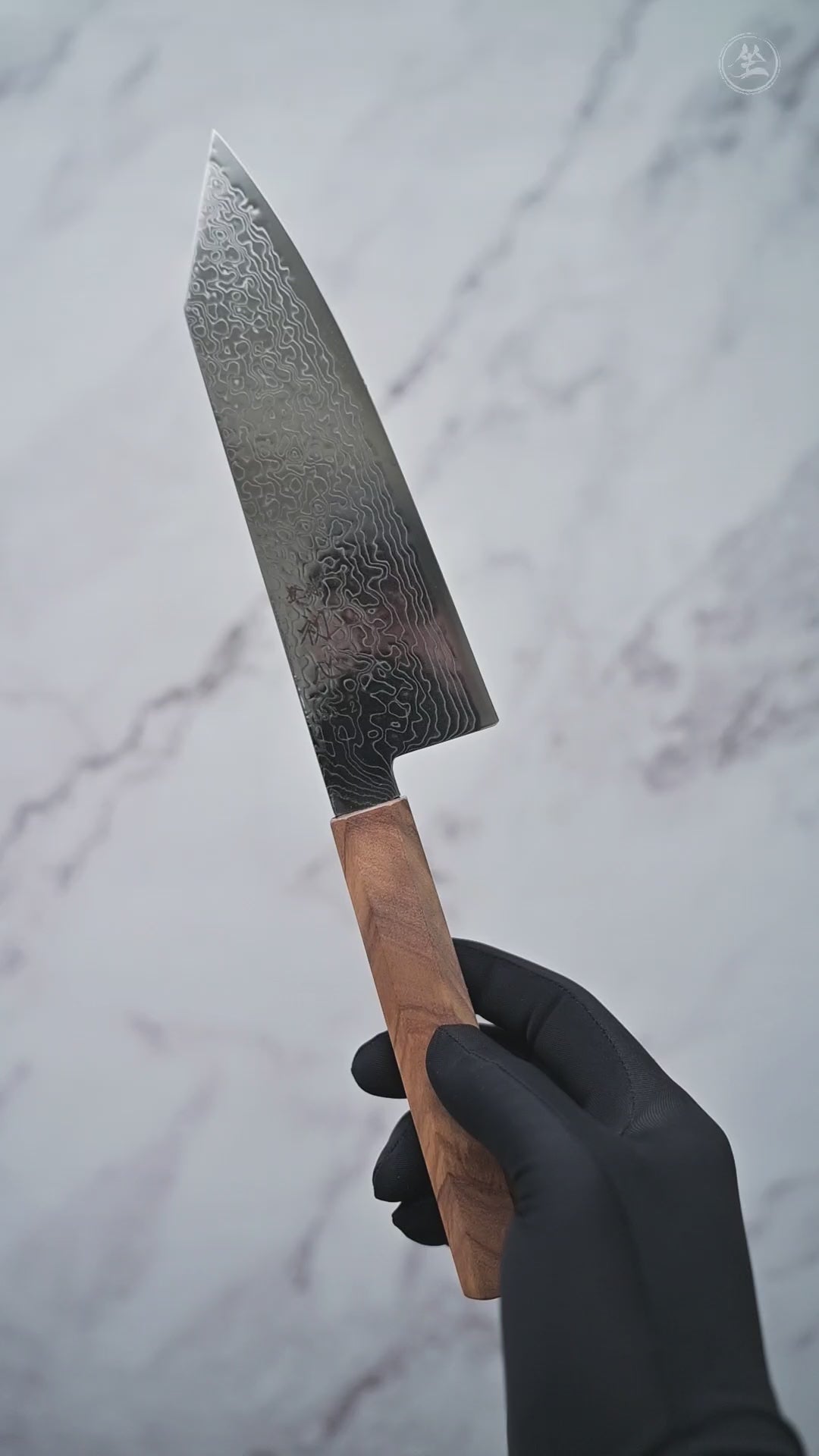 Short video showcasing a damascus SG2 bunka knife from Hatsukokoro, rotating to display the blade, handle, and overall craftsmanship from multiple angles.