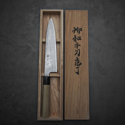 Kitaeji Japanese chef's knife in a wooden box with engraved text on a dark background
