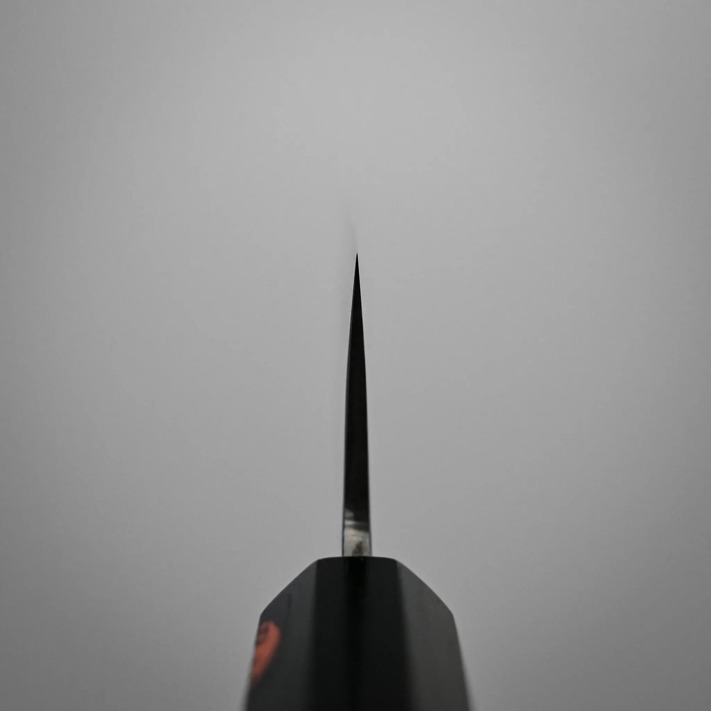 Choil shot of a kasumi Japanese chef's knife blade photographed from above against a plain gray background.