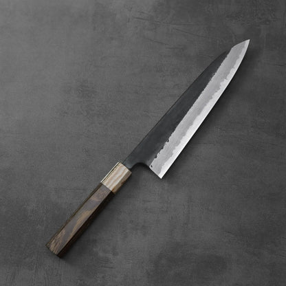 Gyuto with a dark wood handle featuring a damascus pattern and kurouchi finish.