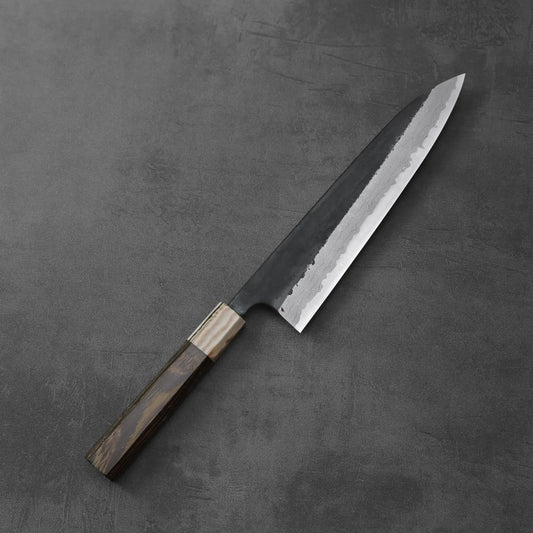 Gyuto with a dark wood handle featuring a damascus pattern and kurouchi finish.