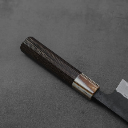 Close-up of a gyuto, featuring kurouchi damascus steel and AS core, blade edge in clear detail.