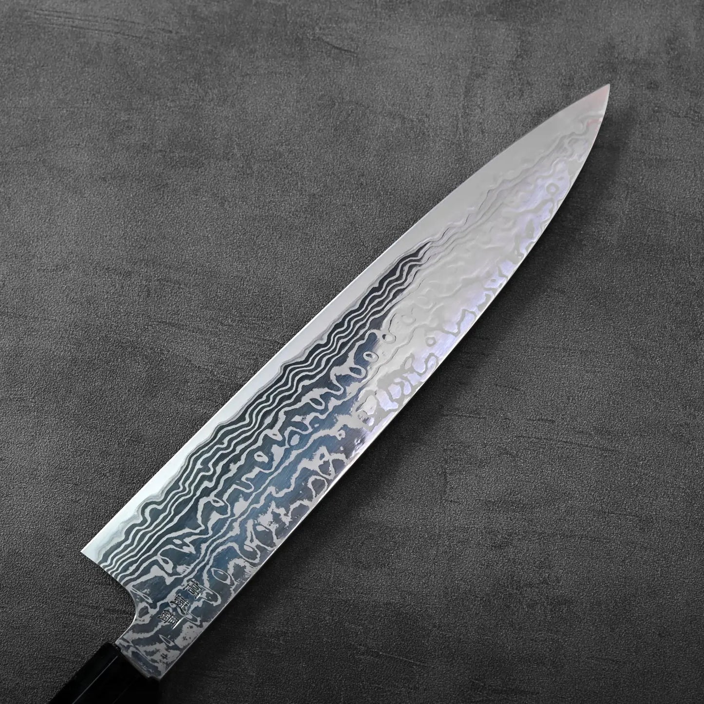Gyuto with damascus pattern and a wavy blade, highlighting its distinctive flowing metal layers.