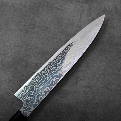 Gyuto with damascus pattern and a wavy blade, highlighting its distinctive flowing metal layers.
